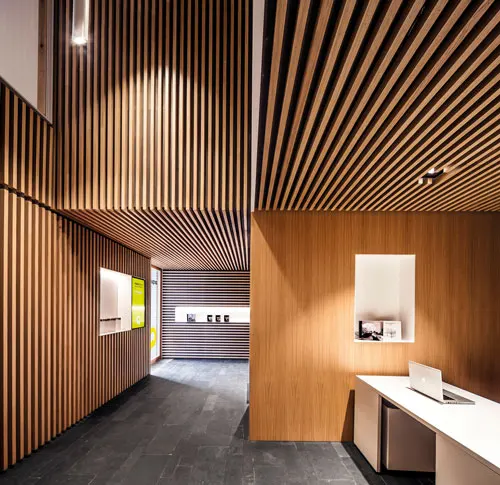 Revestimiento de paramentos verticales y horizontales con perfil rechapado de madera natural de Roble Francés 30x30mm.